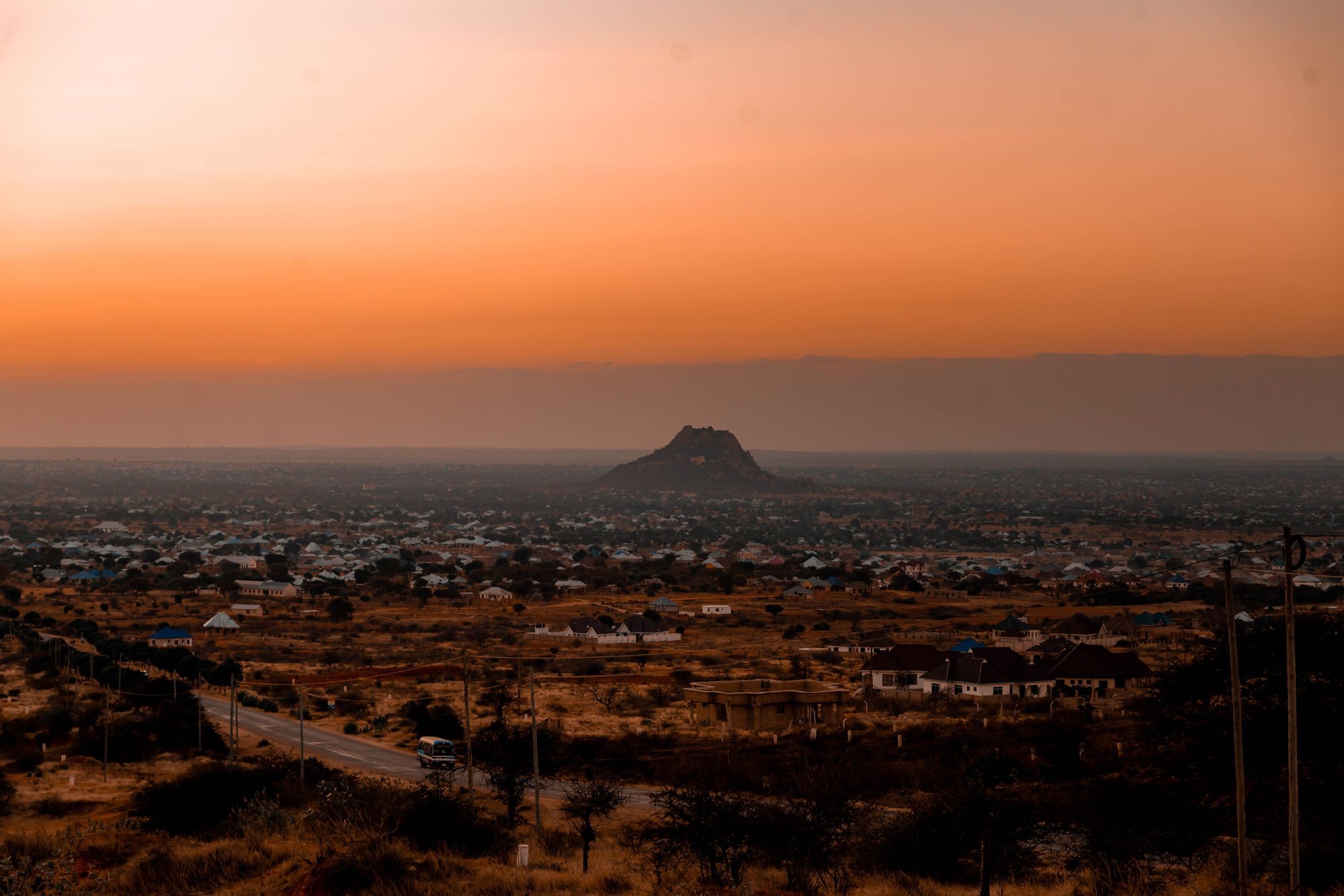 Dodoma at dusk, with a rocky hill rising above the city